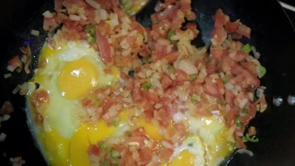 Huevos crudos y pico de gallo tradicional en una sartén — Vídeos de Stock