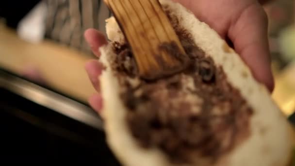パンのスライスに揚げ豆を広げる男性の手 — ストック動画