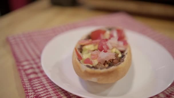 Mollete mexicano tradicional en un plato sobre servilleta a cuadros blanca y roja — Vídeos de Stock