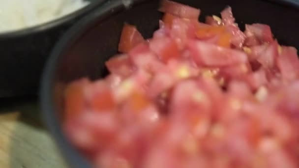 Hackade tomater, lök och chilipaprika separerade i tre svarta skålar — Stockvideo