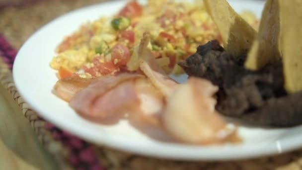 Μεξικάνικου τύπου αυγά, μπέικον, και refried φασόλια με τηγανητές πατάτες τορτίγια σε λευκό πιάτο — Αρχείο Βίντεο
