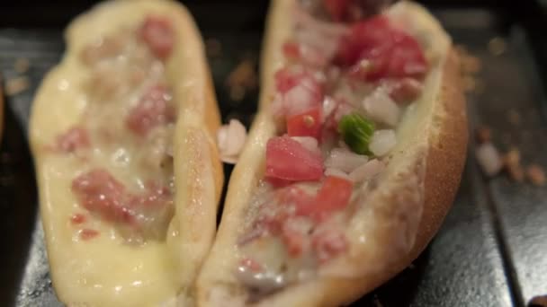 Łyżka dodanie pico de gallo do tradycyjnych meksykańskich molletes powyżej czarnej tacy — Wideo stockowe