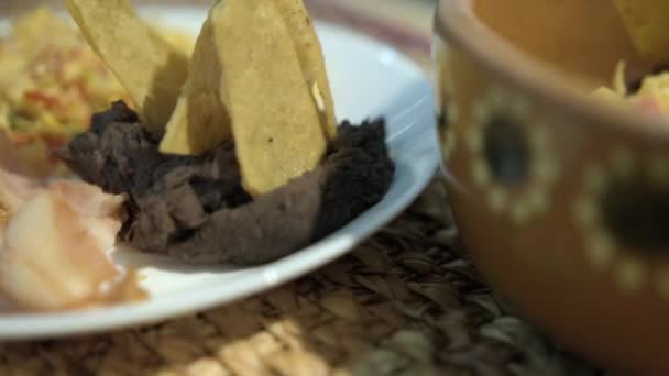 Huevos al estilo mexicano, tocino y frijoles refritos con tortillas fritas en plato blanco — Vídeos de Stock