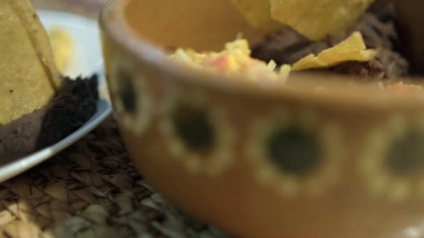 Ovos de estilo mexicano, bacon e feijão refrito com batatas fritas de tortilla no prato branco — Vídeo de Stock