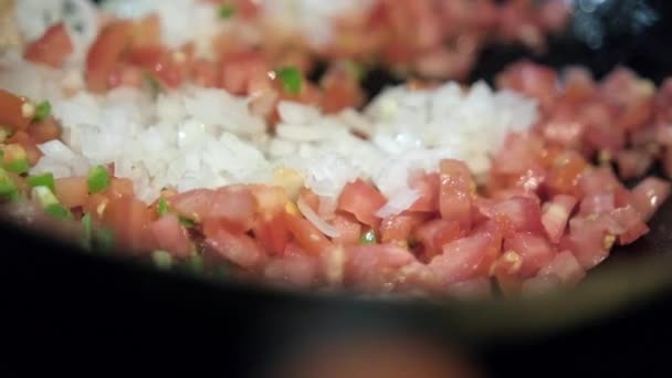 Stek hackad lök, tomater och chilipeppar i en stekpanna — Stockvideo
