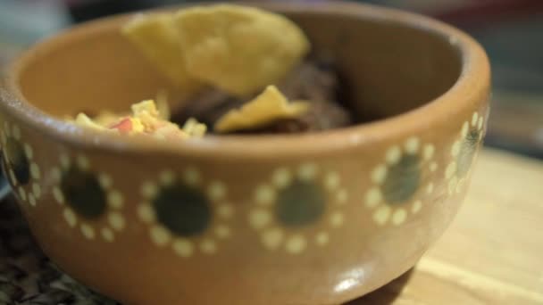 Mexikói stílusú tojás, szalonna, és újrasült bab tortilla chips fehér tányéron — Stock videók