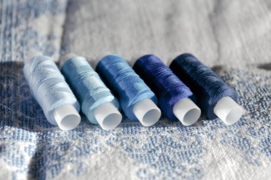 Mavi iplikler. Dikiş bobinleri seti. Mavinin farklı tonlarında birkaç parça ipliğin yakın plan görüntüsü..