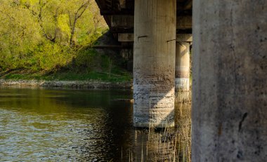 Köprünün güçlendirilmiş beton kolunun tahrip edilmesi. Köprü inşaatı. Sudan gelen beton erozyonu.
