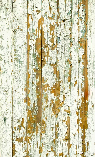 Cracking and peeling white paint on a wall. Vintage wood background with peeling paint. Old board with Irradiated paint. White wooden texture, wood background with old paint peels. Paint desk texture.