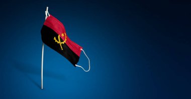 Koyu mavi arka planda Angola maskesi. Angola 'nın bayrağını direğe sallayan tıbbi maske. Virüs saldırısı bayrağı. Salgın koronavirüs COVID-19 'a karşı mücadele bayrağı kavramı. Boşluğu kopyala