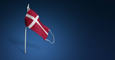 Koyu mavi arka planda Danimarka maskesi. Direğe tıbbi maske takmış Danimarka bayrağı sallıyor. Virüs saldırısı bayrağı. Salgın koronavirüs COVID-19 'a karşı mücadele bayrağı kavramı. Boşluğu kopyala
