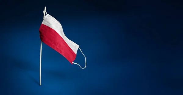 Lengyelország maszk sötétkék háttérrel. Lengyelország zászlaját lobogtatva orvosi maszkra festették a rúdra. A járványos koronavírus elleni küzdelem zászlajának koncepciója COVID-19. Fénymásolási hely — Stock Fotó