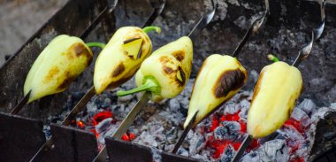 Şişte tatlı biber, kömürün yakın plan bulanık kömüründe kızarmaya hazırlanıyor. dolma biber