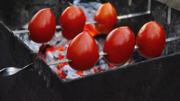 在一个准备在木炭特写上烤烤的斜子上的番茄模糊了背景 复制空间 — 图库照片