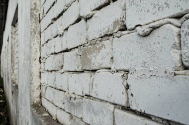 Beyaz boyalı eski tuğla duvar, sağ taraftan perspektif. Açı görünümü, soyut arkaplan fotoğrafı