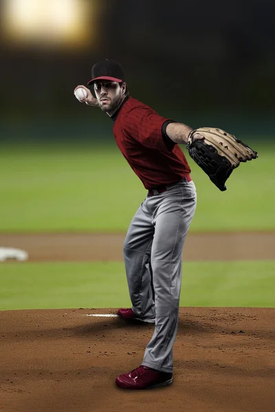 Lanzador jugador de béisbol con un uniforme rojo — Foto de Stock