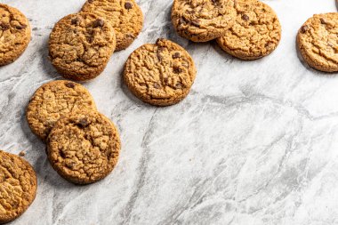 Mermer tezgahta taze pişmiş çikolatalı kurabiyeler. Boşluğu kopyala.
