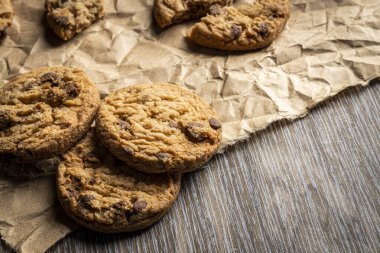 Yeni pişmiş çikolatalı kurabiyeler ahşap bir masada yazılı. Boşluğu kopyala.