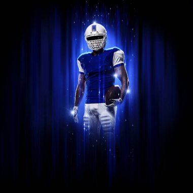 Süper kahraman pozu veren futbolcu siyah arka planda mavi ışıklarla mavi üniforma giyiyor..