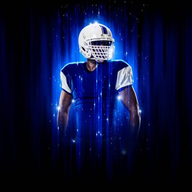 Süper kahraman pozu veren futbolcu siyah arka planda mavi ışıklarla mavi üniforma giyiyor..