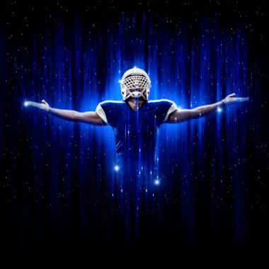 Süper kahraman pozu veren futbolcu siyah arka planda mavi ışıklarla mavi üniforma giyiyor..