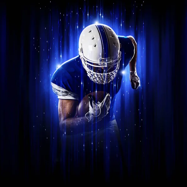 Football Player player with a superhero pose  wearing a blue uniform on a black background with blue lights.