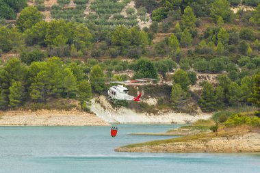 İtfaiye helikopteri İspanya 'nın Alicante kentindeki Guadalest rezervuarından su topluyor..