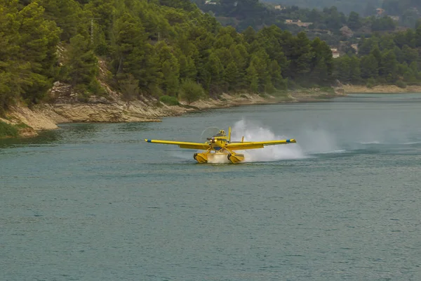 İtfaiyecilerin uçağı Guadalest rezervuarından su topluyor, Alicante, İspanya.