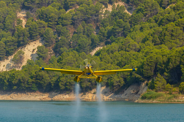 Firefighters plane collecting water from the Guadalest reservoir, Alicante, Spain.
