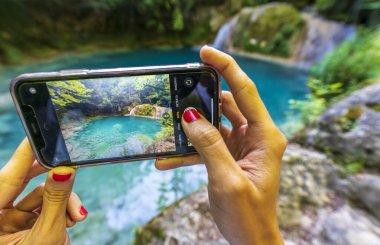 Kadın cep telefonuyla fotoğraf çekmiş..