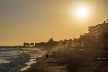 Günbatımında Villajoyosa plajı, kumsalda güneş ışığı, Alicante, İspanya.