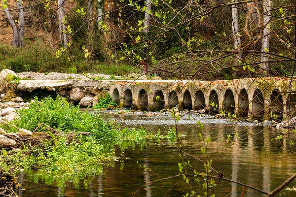 Bridge with small arches over the Serpis river next to the old train track in Villalonga, Valencia, Spain.