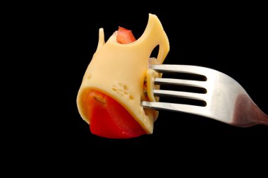 peynir ve domates üzerinde siyah arka plan üzerine çatal