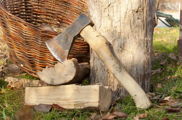 Gehäckseltes Brennholz in einem Korb mit einer Axt gestapelt — Stockfoto