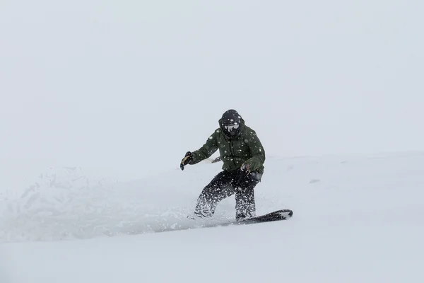 Αρσενικό snowboarder σνόουμπορντ στο φρέσκο χιόνι στην πίστα σκι — Φωτογραφία Αρχείου