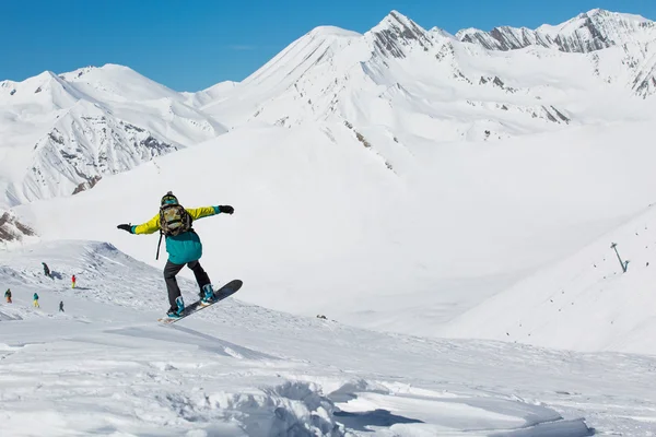 Ο άνθρωπος snowboarder σνόουμπορντ στο φρέσκο λευκό χιόνι στην πίστα σκι, ηλιόλουστη χειμερινή ημέρα — Φωτογραφία Αρχείου