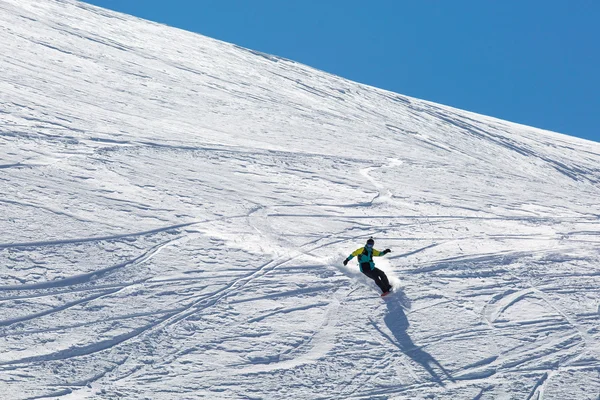 Ο άνθρωπος snowboarder σνόουμπορντ στο φρέσκο λευκό χιόνι στην πίστα σκι, ηλιόλουστη χειμερινή ημέρα — Φωτογραφία Αρχείου