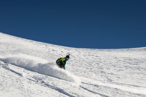 Uomo snowboarder snowboard sulla neve fresca bianca sulla pista da sci nella giornata invernale soleggiata — Foto Stock