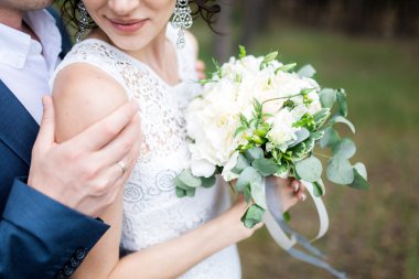 Düğün çifti el ele tutuşuyor.