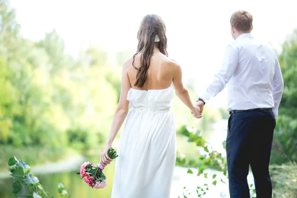 Свадебная пара держится за руки — стоковое фото