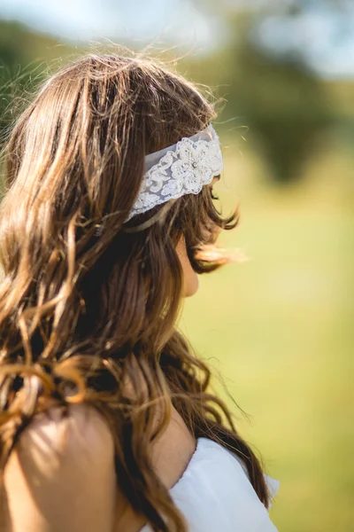 A noiva em um vestido de noiva com uma faixa branca no cabelo — Fotografia de Stock