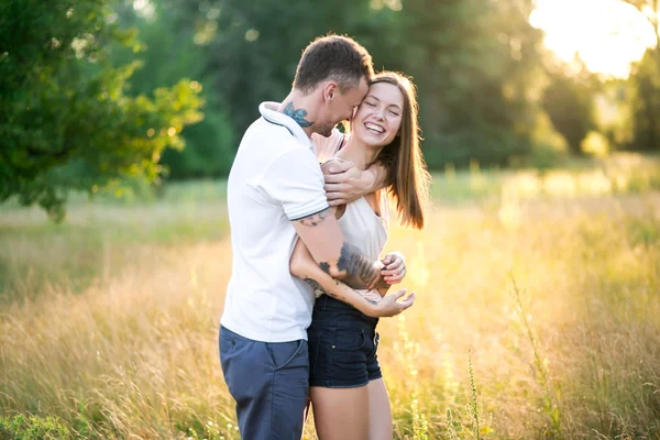 Mooie jonge liefdevolle paar knuffelen in de natuur — Stockfoto