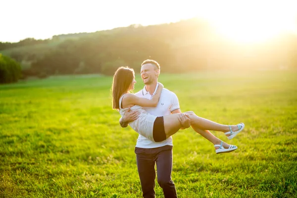 Mooie jonge liefdevolle paar knuffelen in de natuur — Stockfoto