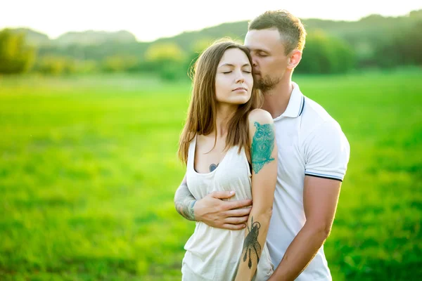 Beautiful young loving couple hugging in nature — Stock Photo, Image