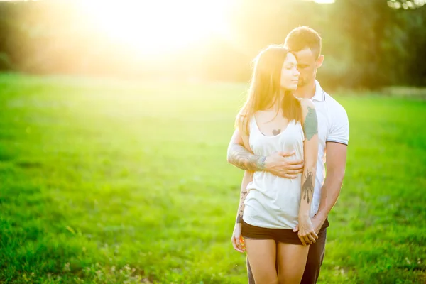 Mooie jonge liefdevolle paar knuffelen in de natuur — Stockfoto