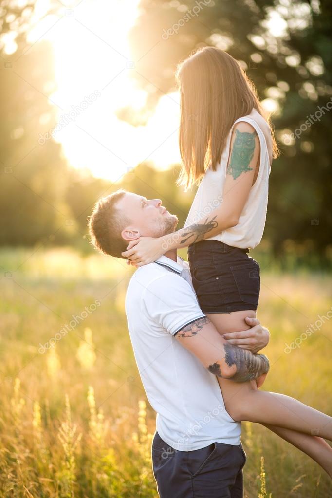 Beautiful young loving couple hugging in nature