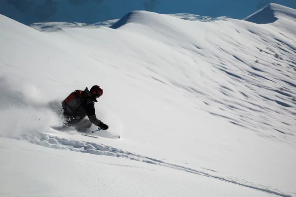 Mężczyzna w świeży śnieg na stoku narciarskiego na słoneczny zimowy dzień w ośrodku narciarskim w Gruzji — Zdjęcie stockowe