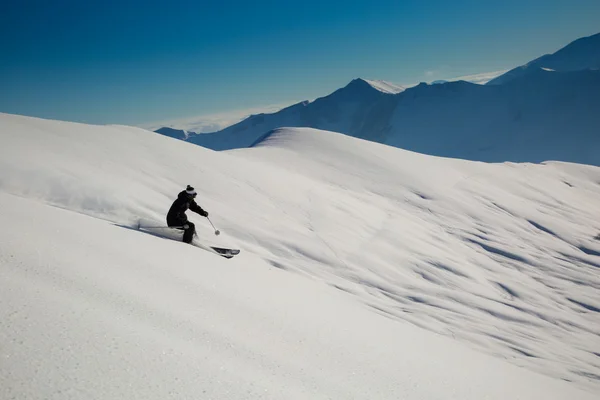 Männchen im Neuschnee auf der Skipiste an einem sonnigen Wintertag im Skigebiet in Georgien — Stockfoto