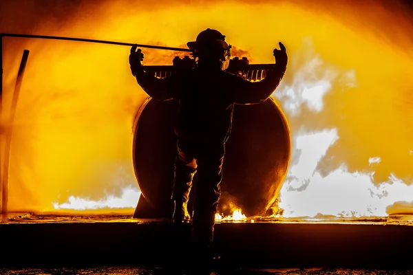 Пожарный стоит перед огнем — стоковое фото