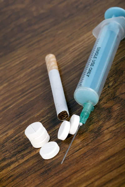 Addiction concept with syringe, cigarette and pills — Stock Photo, Image